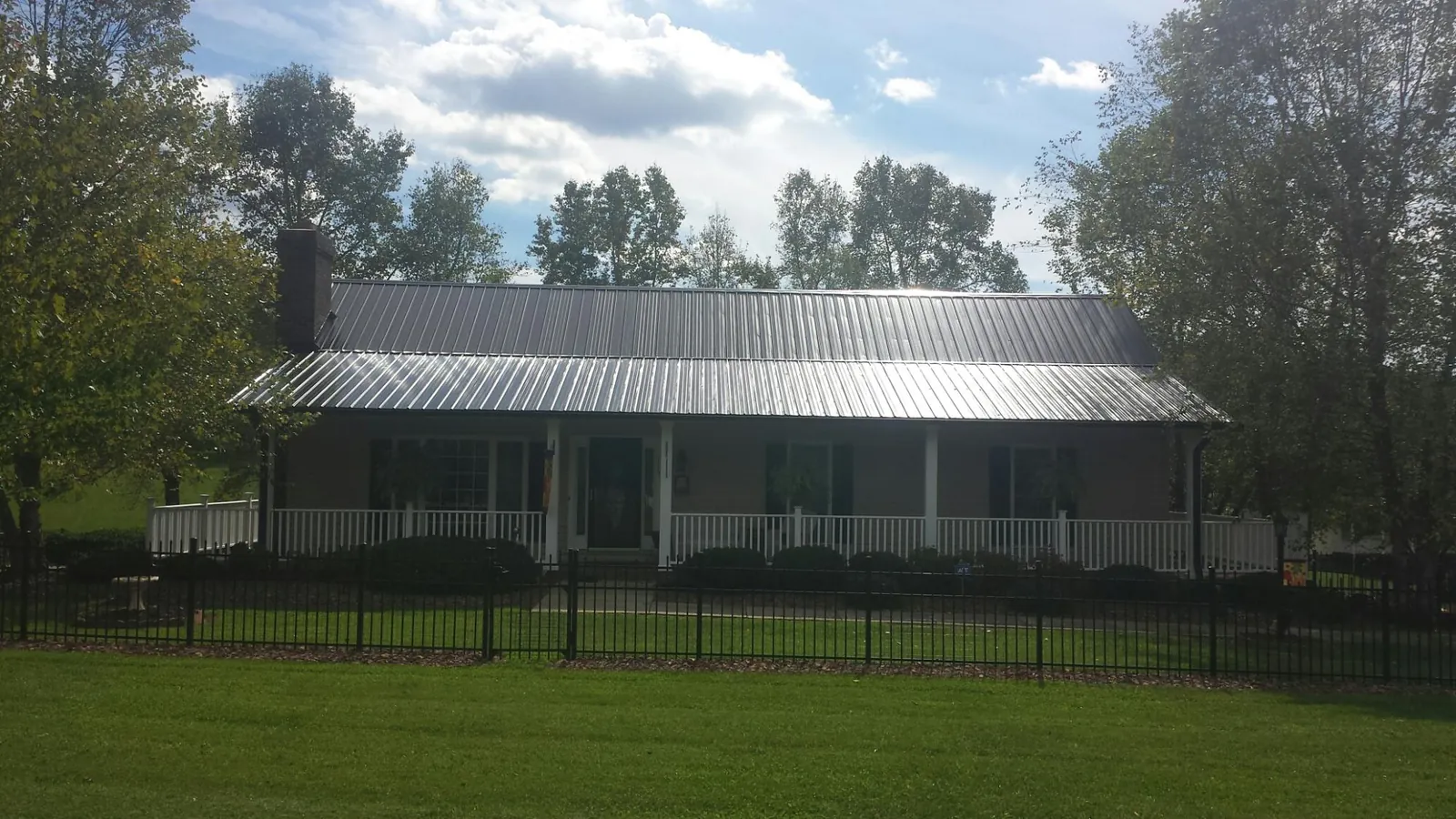 Gray metal roof on a brick ranch with a full width front porch — Gutter Guard Installation work by our crew in East Weymouth
