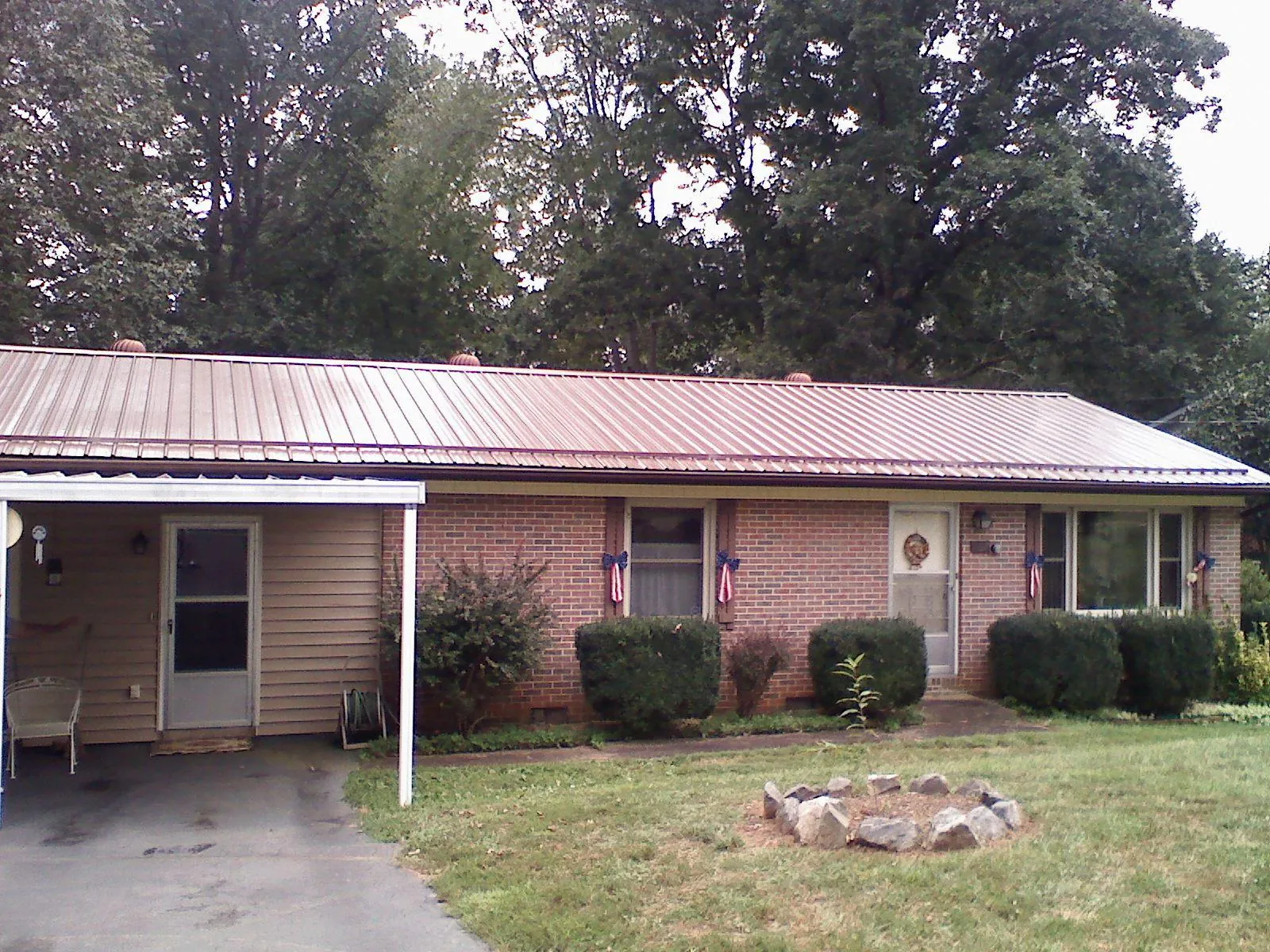 Bronze metal roof and carport on a brick ranch home — Roof Repair work by our crew in East Weymouth